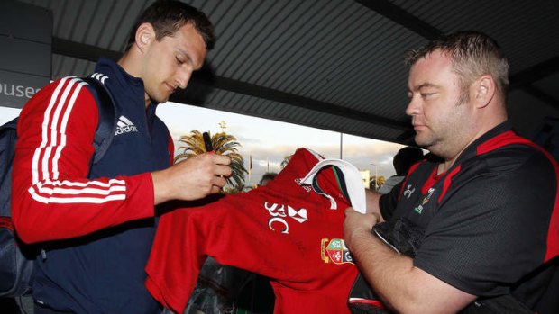 Flying in: British and Lions captain Sam Warburton signs a jersey for a fan at Perth airport.