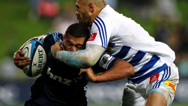 Charles Piutau of the Blues is tackled by Bryan Habana of the Stormers.