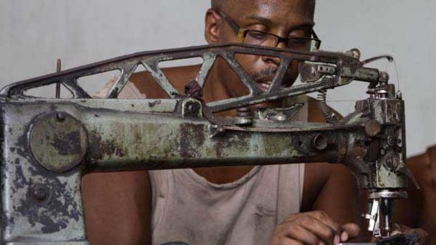 Manuel Cardenas repairs shoes in La Habanera state-run workshop in Havana, Cuba.