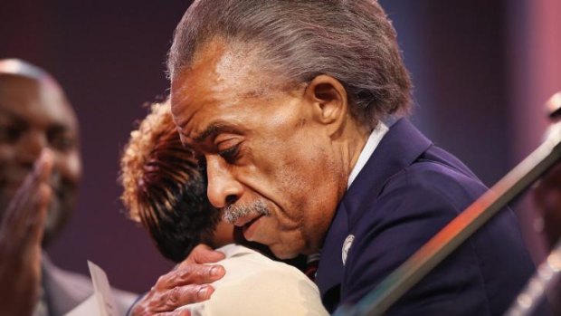 Reverend Al Sharpton hugs Lesley McSpadden, the mother of slain teenager Michael Brown, at a church service on Sunday.