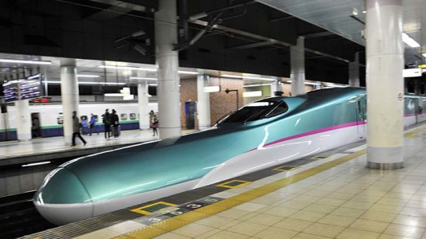 Japan's new bullet train, the 'Hayabusa' passes through a station.