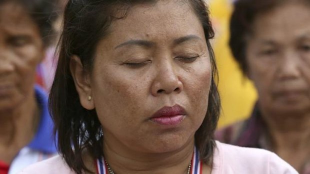 Thai anti-government protesters stand in silence during a condolence ceremony Thursday for those who were killed in an attack on Wednesday night.