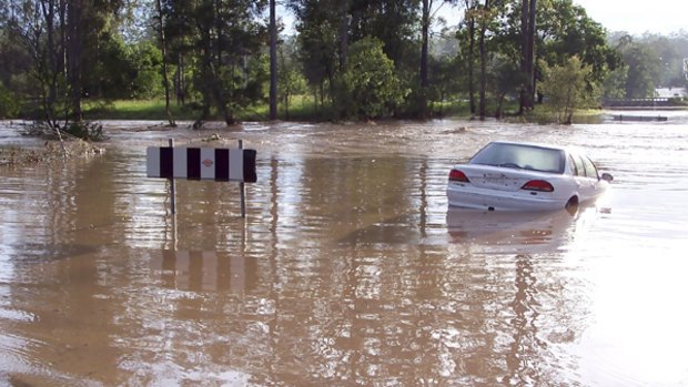 A car lies stranded in Goodna, west of Brisbane, which was hit by flash floods after Wednesday night's severe storm. The driver escaped.