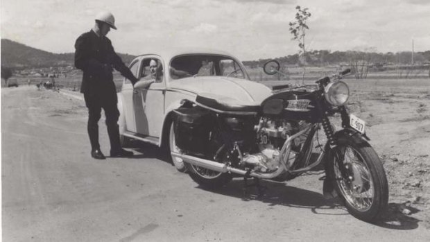 A member of ACT Police pulls over a Canberra motorist on his Triumph - 1965. Image courtesy of the AFP Museum.