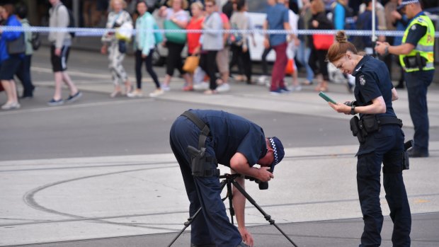  Police examine the roadway at the intersection of Swanston and Flinders streets on January 20, 2017. 
