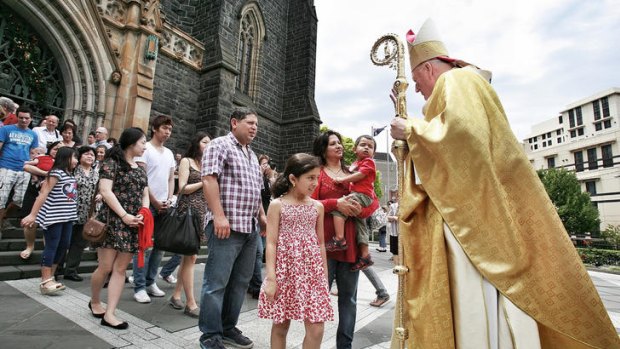 Archbishop Denis Hart greets parishioners after the Christmas service at St Patrick's Cathedral in Melbourne.