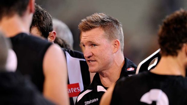 Collingwood coach Nathan Buckley speaks to his players at quarter-time.