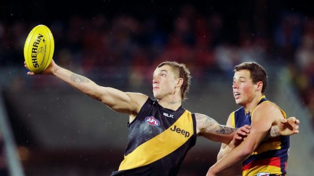 Dustin Martin of the Tigers wins the ball in front of Luke Brown of the Crows.