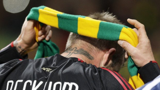 David Beckham puts on a green and yellow scarf in support of the anti-Glazer protest movement at Manchester United .... or is that a Socceroos scarf?