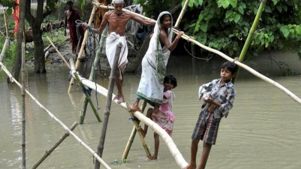 Villagers use a bamboo structure to move across a flooded village in Morigaon district of north-eastern Assam state.