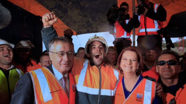 "We're gunna win" ... Jamie Scown, a steel fixer, is confident as he hugged Julia Gillard and Wayne Swan at the Googong Dam site near Queanbeyan yesterday.