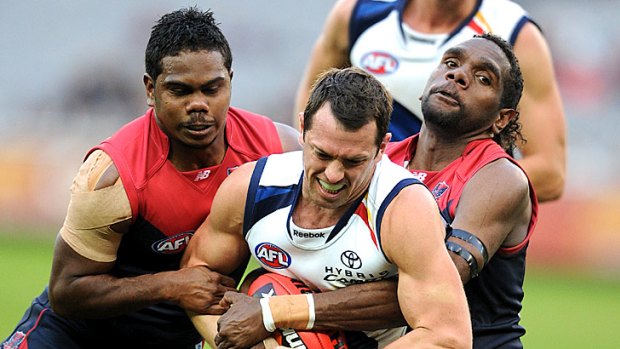 Demons Austin Wonaeamirri and Liam Jurrah keep a tight hold on Eagle Michael Doughty during a cathartic match for Melbourne.