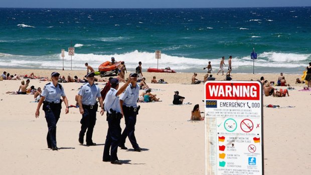 Police officers patrol a Gold Coast beach.