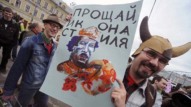 A participant stages a performance as he attends a May Day rally on International Workers' Day in Moscow. The placard reads, "farewell icon of style".