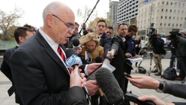 Round one: Essendon chairman Paul Little reads a statement after the Bombers' opening gambit in the Federal Court on Friday. 