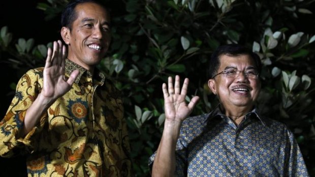 Indonesian president-elect Joko Widodo (left) and his running mate Jusuf Kalla wave to the media at a press briefing in the garden of his home in Jakarta.