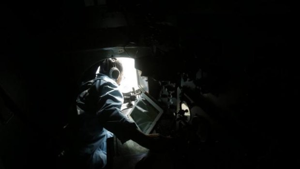 Vietnamese military officer Duong Van Lanh looks out a window while working onboard a Vietnamese airforce AN-26 during a mission to find the missing Malaysia Airlines flight MH370 