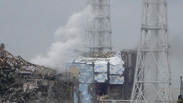 The damaged No. 4 unit of the Fukushima Daiichi nuclear complex. White smoke is billowing from the No. 3 unit.