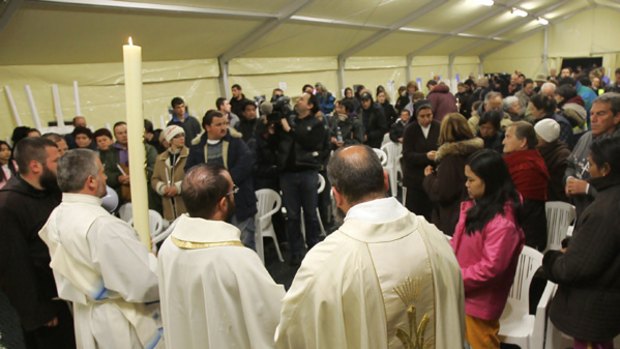 Prelates celebrate an Easter vigil service in a tent camp in L'Aquila attended by earthquake survivors.