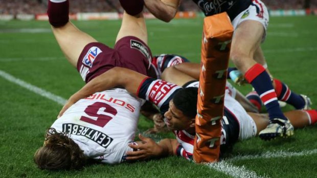 Floored: Manly winger David Williams is driven into touch.
