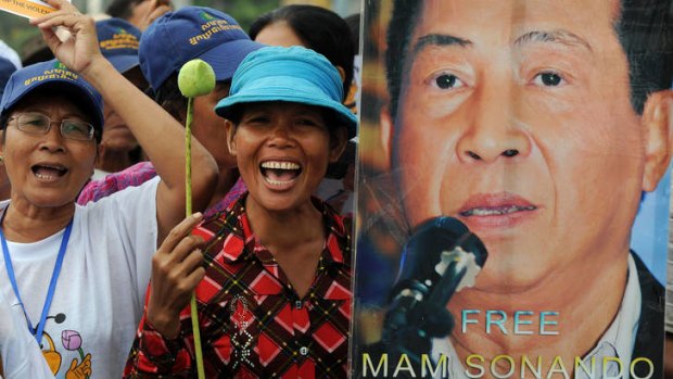 Cambodian protesters shout slogans next to a portrait of Mam Sonando on Monday.