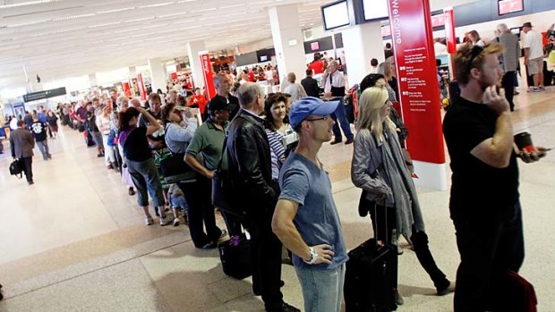 Passengers wait to be rescreened by security after a man entered Melbourne Airport's 'sterile' zone through the exit.