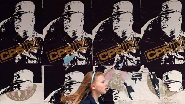 A girl runs past posters of Bosnian Serb war crimes fugitive Ratko Mladic in centre of Belgrade.