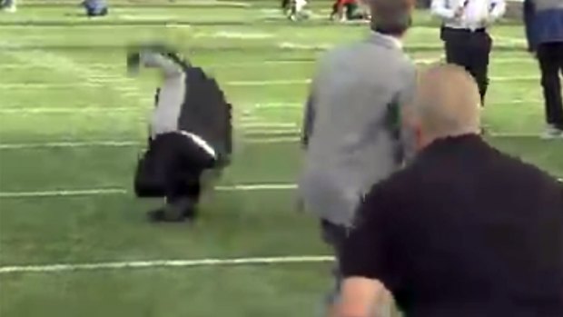 Rob Ford, left, hits the turf during an American football demonstration for the TV cameras.