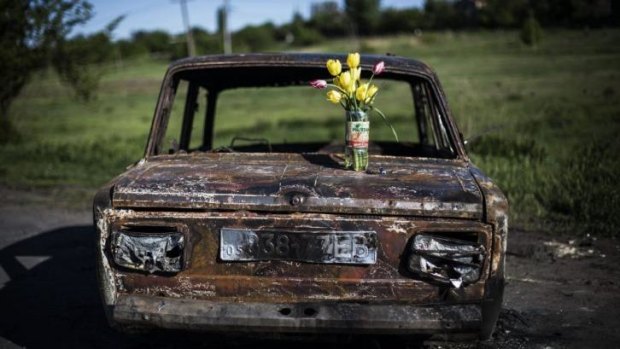 A bouquet of flowers stands on a burned car at the site of clashes between pro-Russia gunmen and the Ukrainian army, four kilometers north of Slovyansk, Ukraine. 