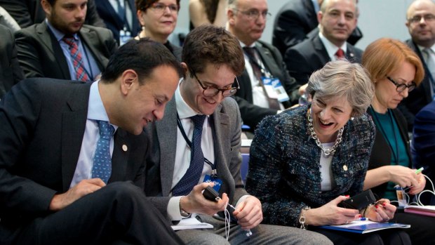 Irish Prime Minister Leo Varadkar, left, shows his decorative socks to British Prime Minister Theresa May,  during a round table meeting at an EU summit in Goteborg, Sweden on November 17.