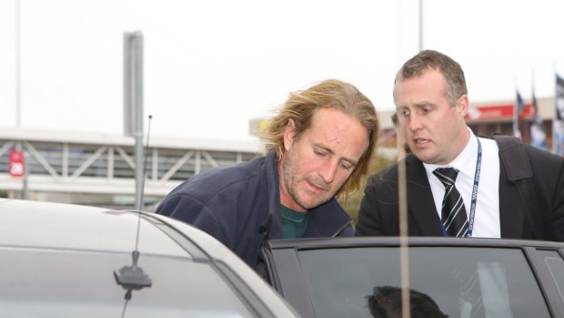 Scott Allen Miller being escorted by police after he was extradited from NSW in July.