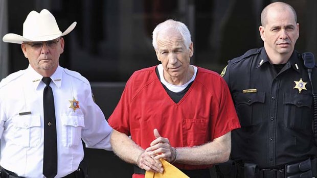 Jerry Sandusky (centre) leaves the Centre County Courthouse in Pennsylvania after his sentencing.