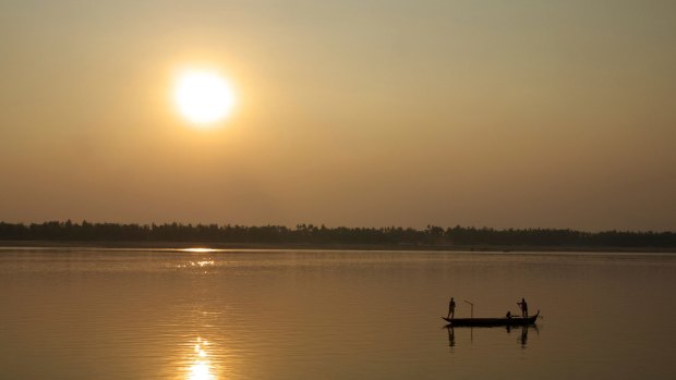 Fishermen set out nets as the sun sets over the Mekong River in Cambodia.