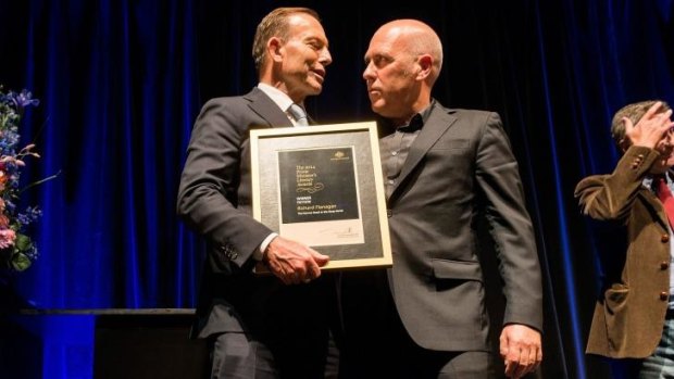 'I'll leave litterateurs to make their comments on politics': Tony Abbott hands Richard Flanagan the Prime Minister's Literary Award for fiction.