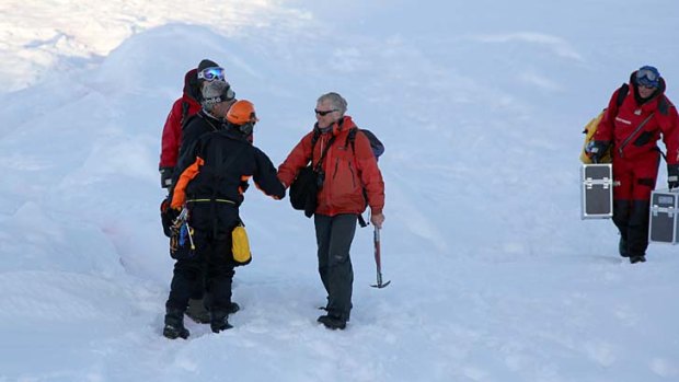 Greg Mortimer (with ice axe) arrives on an ice floe next to the Aurura Australis after being rescued from the Akademik Shokalskiy.