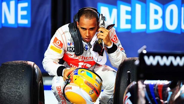 Second-placed Lewis Hamilton checks out Vettel's car.