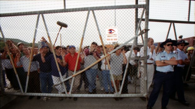 Picketers push up against a fence holding them out of Swanson Dock, Melbourne. April 8, 1998.