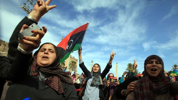 Libyans wave their new national flag as they celebrate in the streets of Tripoli.