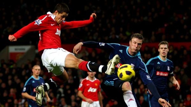 Javier Hernandez of Manchester United shoots at goal under pressure from Robert Huth of Stoke City.