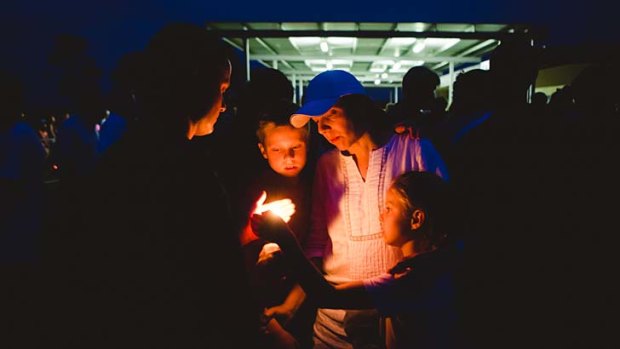 Mourners light candles at the vigil to remember Luke.