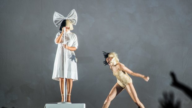 As she had in Melbourne, Sia stood still in the background and sang over a tape of her greatest hits for 90 minutes while her dancers put on a tightly choreographed contemporary ballet. 
