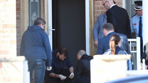 Police at the scene of one of the raids in Guildford.