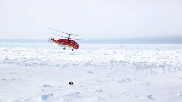 A helicopter from the Chinese icebreaker Xue Long hovers over an ice floe near the Australian icebreaker Aurora Australis, to see if it's a good place to land during the rescue mission.