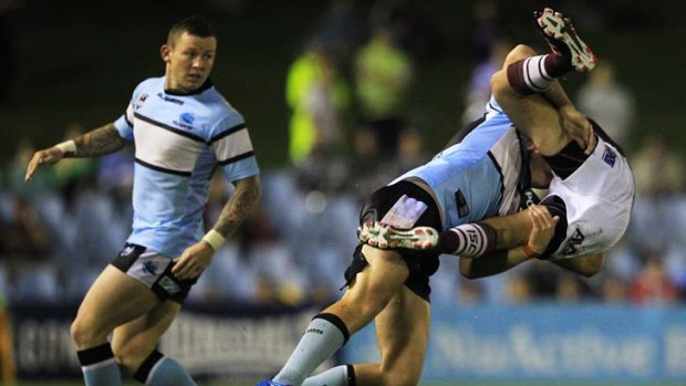 Shark pounces &#8230; Cronulla's John Williams tackles Manly's Michael Oldfield at Toyota Park last night, closely watched by Todd Carney.