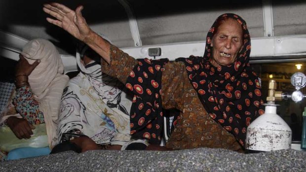 A relative of Farzana Iqbal wails over her body in the back of an ambulance.