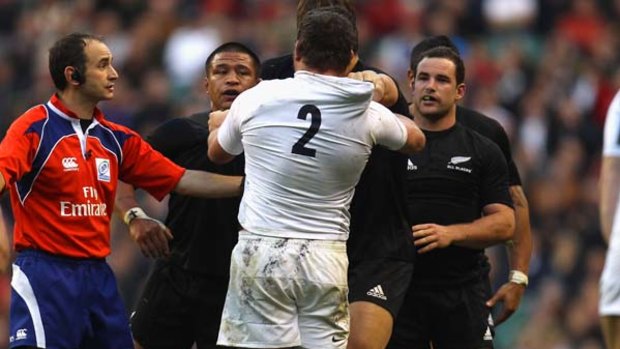 Lewis Moody of England holds his head after an alleged headbutt from Keven Mealamu (L) who challenges Steve Thompson.