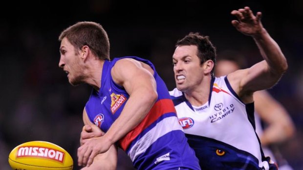 Old-school: Western Bulldogs captain - and 2011 best and fairest - Matthew Boyd (left) playing against Adelaide this year in a jumper similar to the one the club will wear next year.