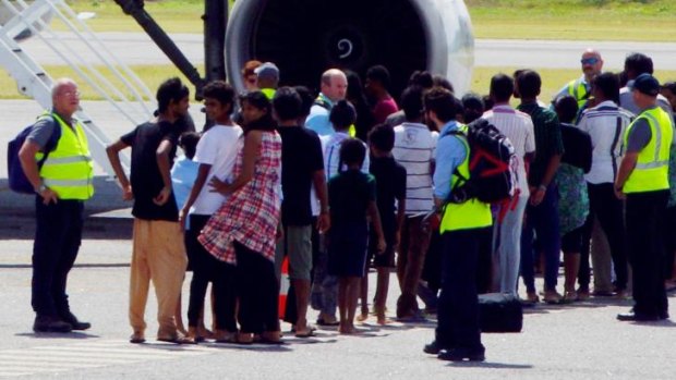 Plight of Tamils: A group of asylum seekers get on board an airplane at Cocos Island on Sunday, July 27, en route to Curtin detention centre in Western Australia.