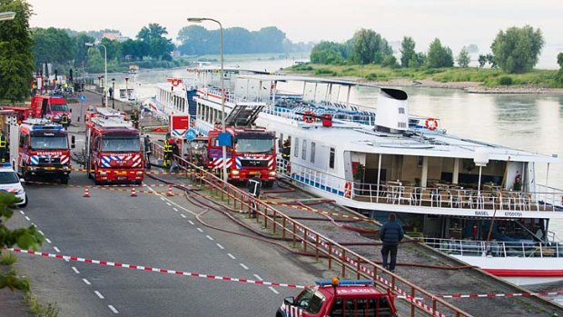 A fire brigade pumps water out from the Swiss cruise river ship Britannia to keep it afloat in the eastern Dutch city of Zutphen, on the IJssel River.