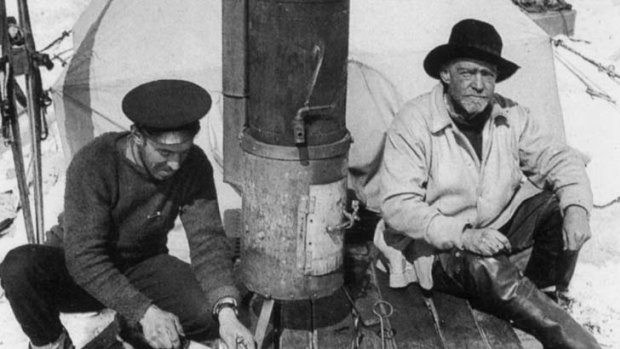Photographer Frank Hurley, left, and Sir Ernest Shackleton sit before the entrance to their tent.